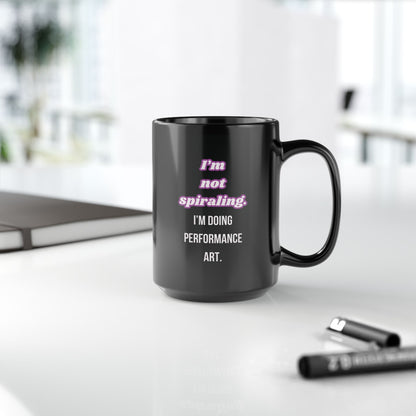 Black mug with humorous text on a desk with office items.