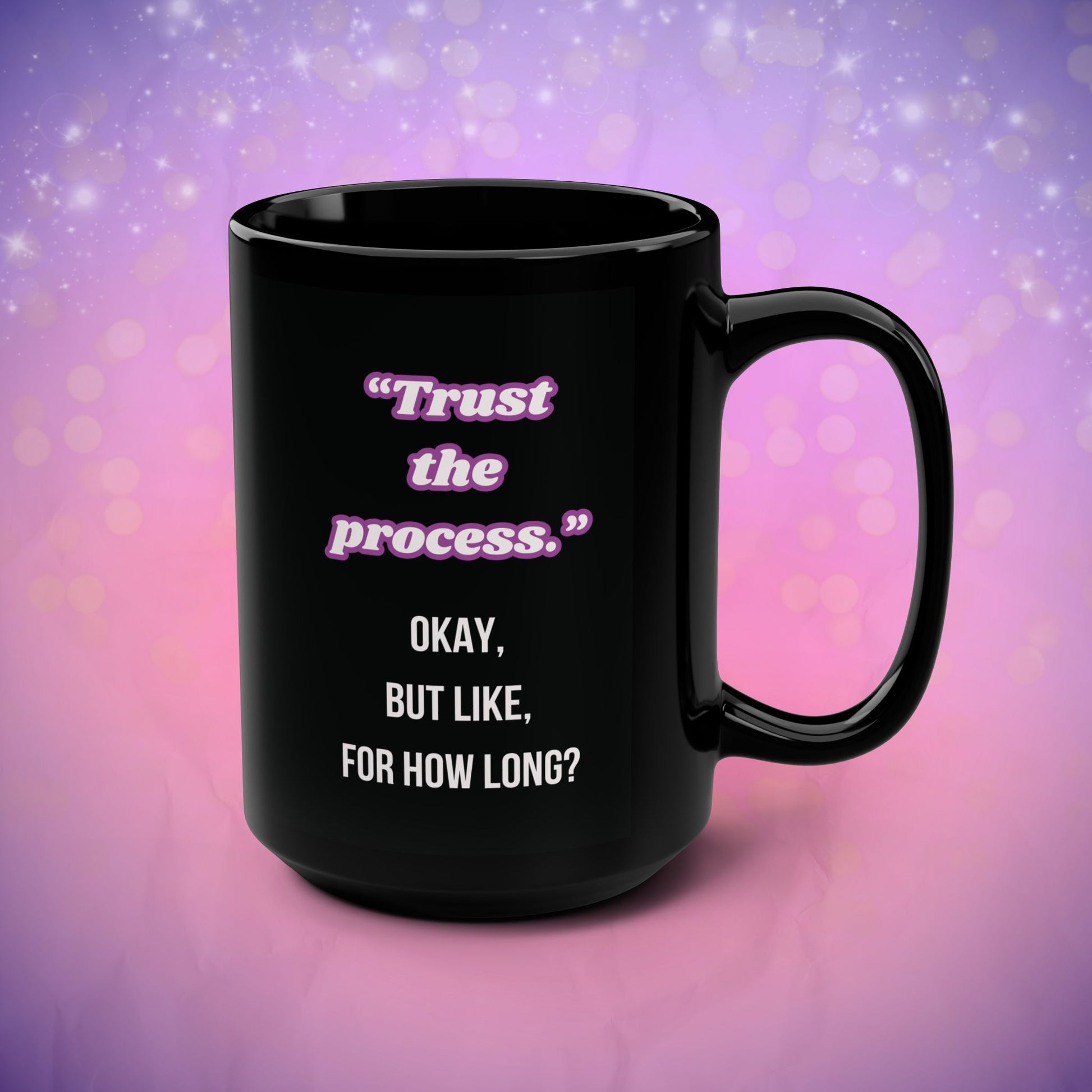Black mug with motivational quote on a purple and pink gradient background