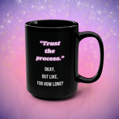 Black mug with motivational quote on a purple and pink gradient background