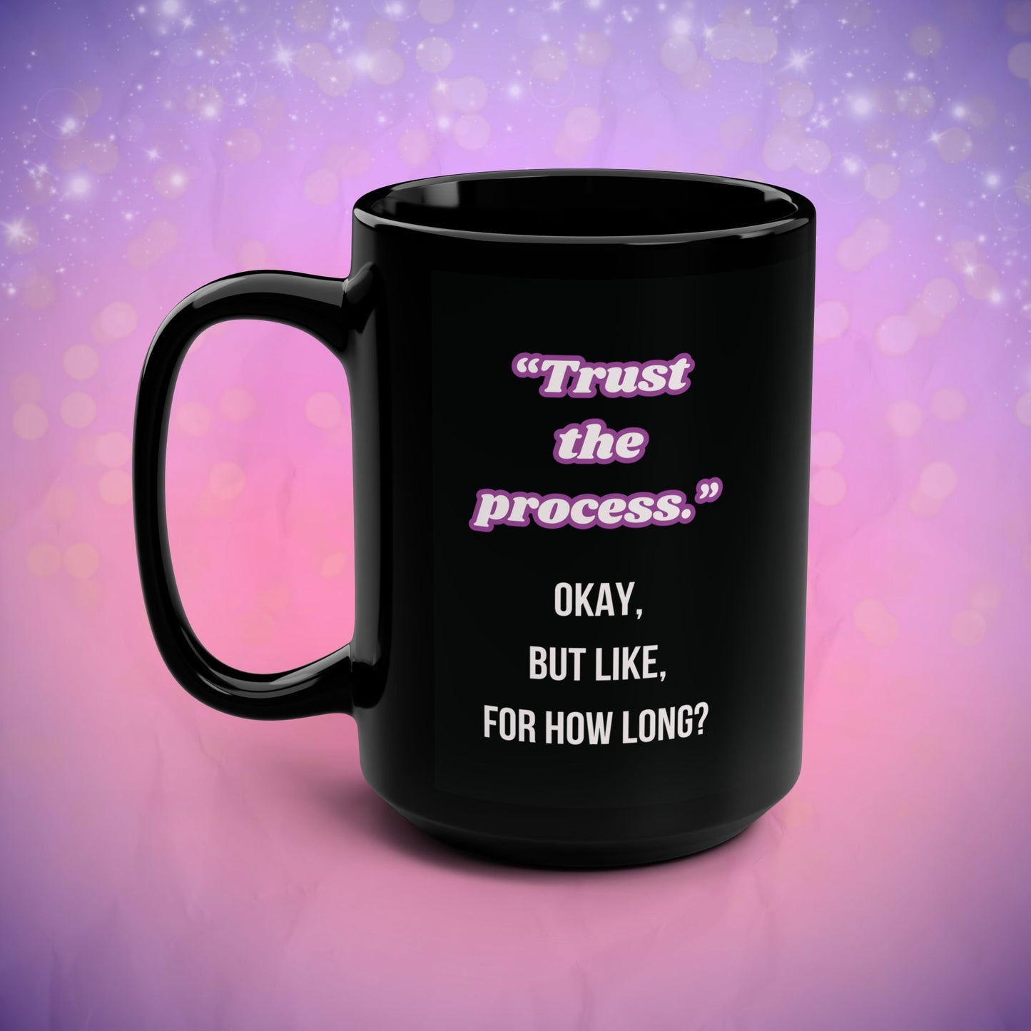 Black mug with motivational quote on a gradient purple and pink background