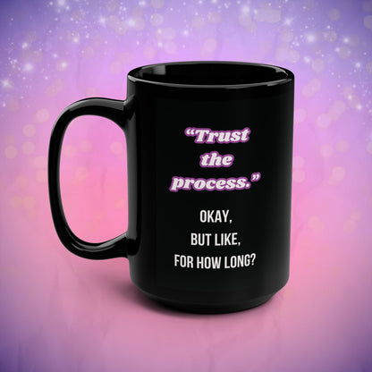 Black mug with motivational quote on a gradient purple and pink background