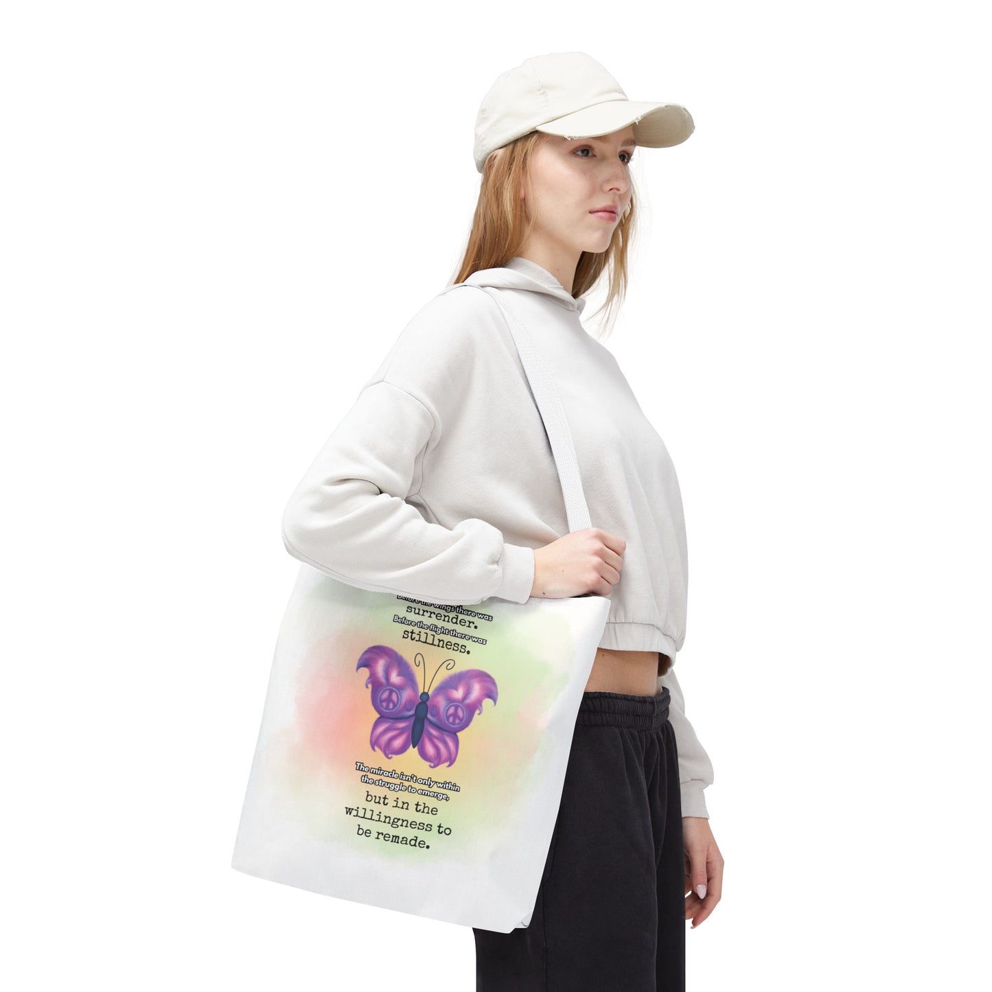 Person holding a tote bag with a butterfly design and text on a white background