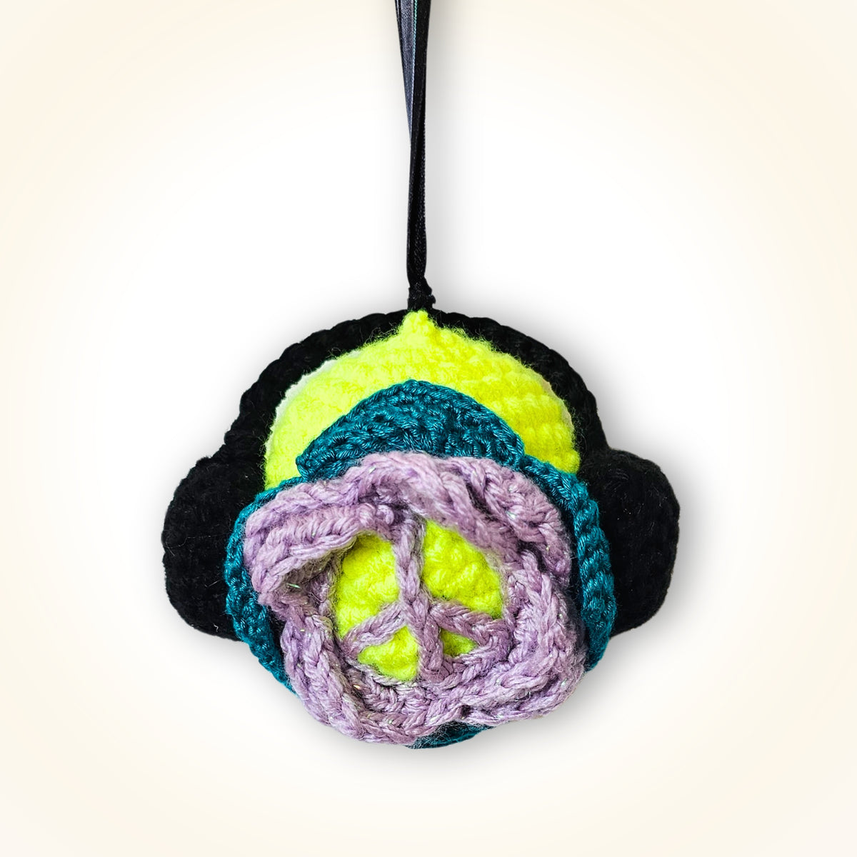 Back view of Groovy Gus showing his colorful layered crochet design and lavender peace sign detail.