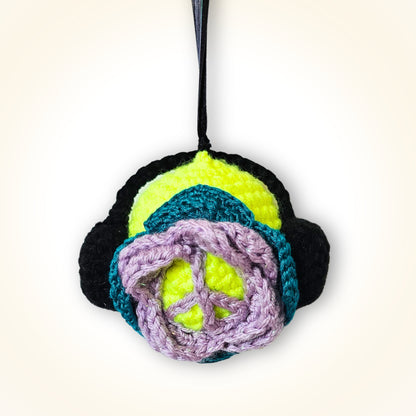 Back view of Groovy Gus showing his colorful layered crochet design and lavender peace sign detail.
