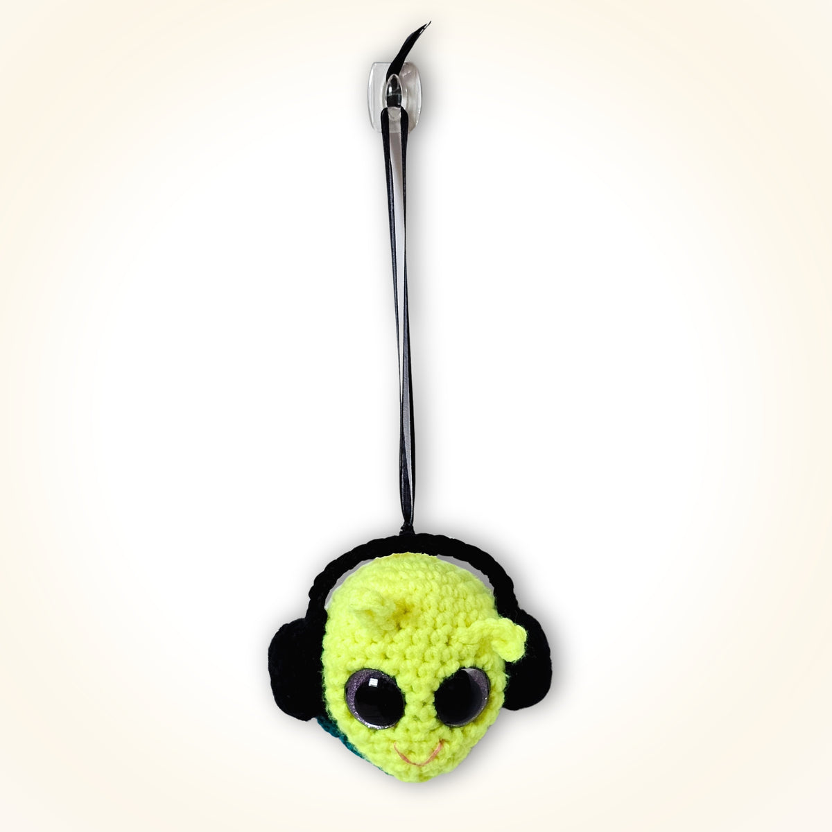 Full front view of Groovy Gus hanging by his black ribbon as a bright handmade crochet decorative keepsake.