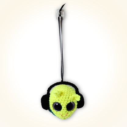Full front view of Groovy Gus hanging by his black ribbon as a bright handmade crochet decorative keepsake.