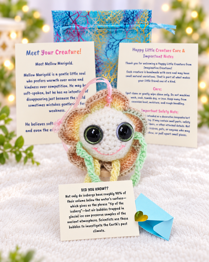 Complete unboxing set for Mellow Marigold showing handmade crochet flower plush, printed personality card, mystery message envelope, and pouch.