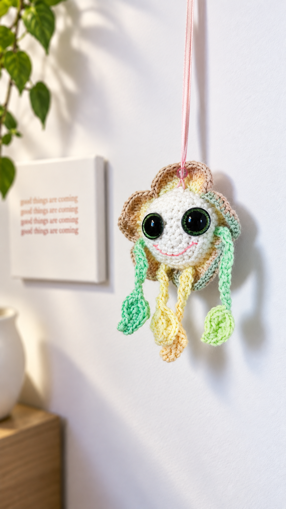 Mellow Marigold crochet hanging flower ornament suspended against a neutral indoor wall.