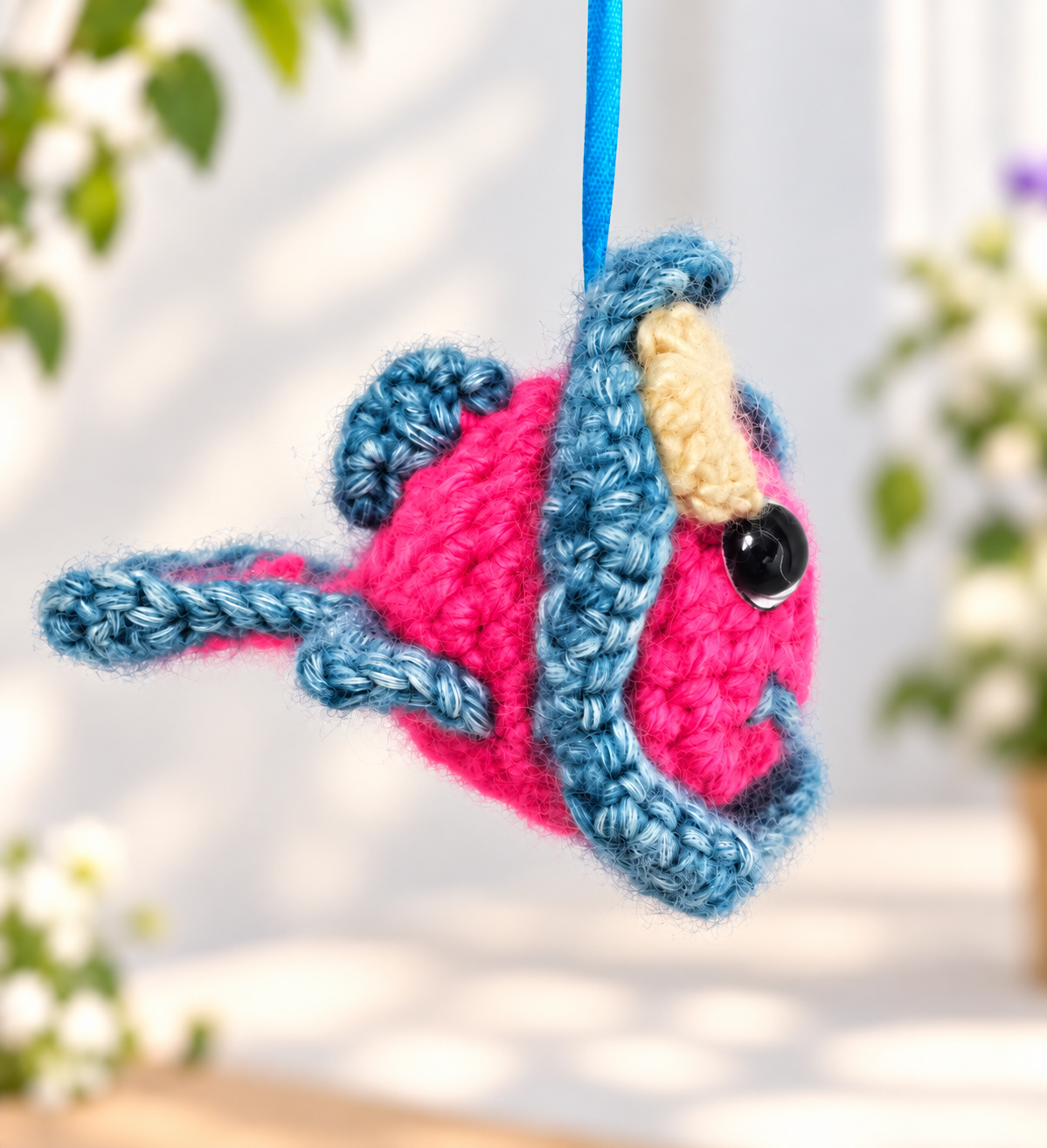 Angled view of Pinky Bluefin crochet hanging ornament positioned as if swimming through the air.