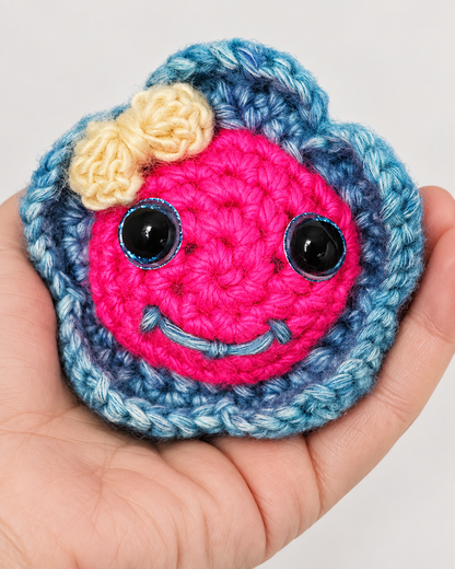 Hand holding Pinky Bluefin handmade crochet fish plush in an open palm to display size and scale.