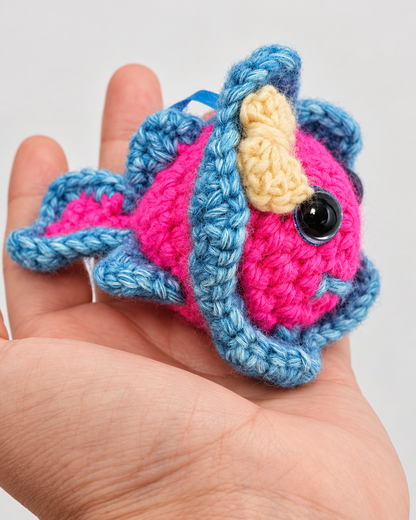 Side profile of Pinky Bluefin held in a hand showing her blue tail fins and pink body structure.