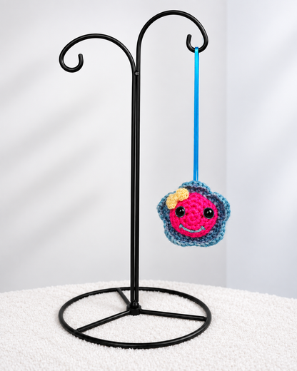 Pinky Bluefin hanging by her blue ribbon from a black metal ornament display stand.  
