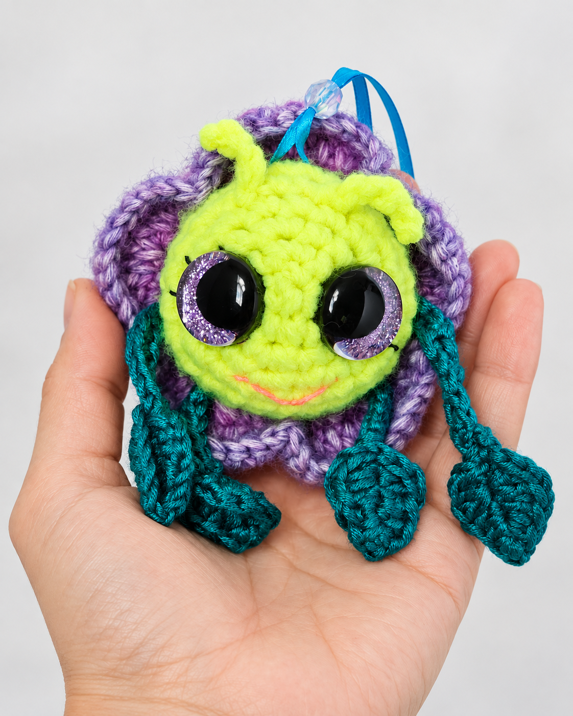Pitalian the alien handmade crochet plush resting in an open palm to show size and scale.