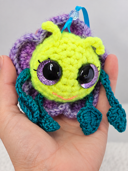 Side angle of Pitalian the alien held in a hand showing the leafy green limbs and lavender petal layers.