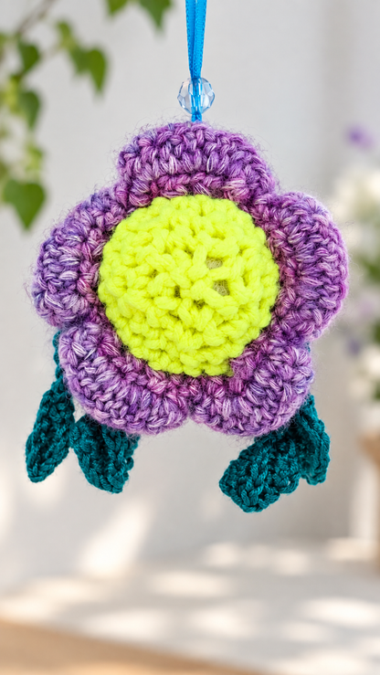Rear view of Pitalian the alien showing the purple crochet flower petal arrangement and blue hanging loop.